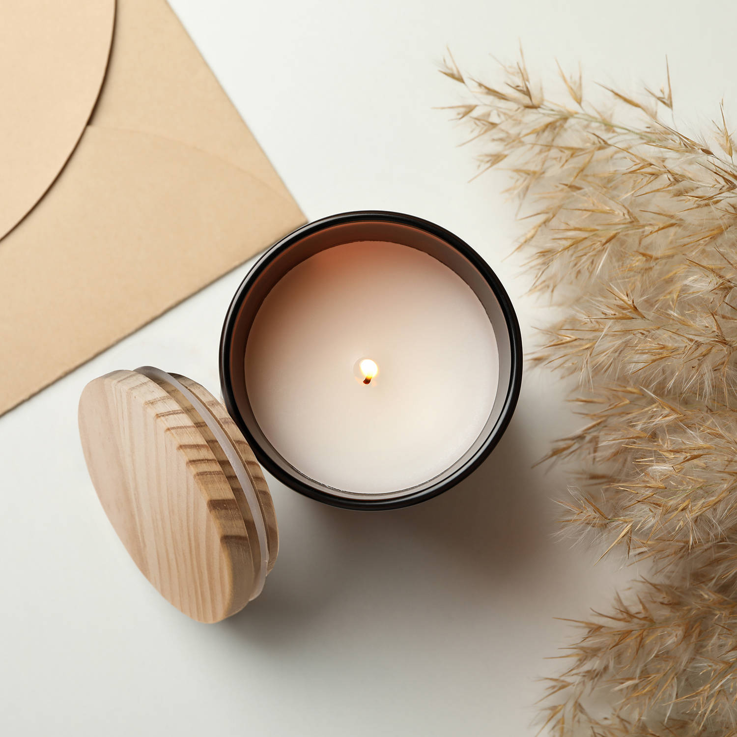 Scented candle, envelope and reed on white background